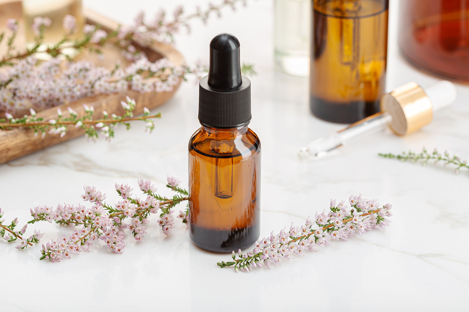 Heather essential oil on amber bottle still life. Herbal remedie